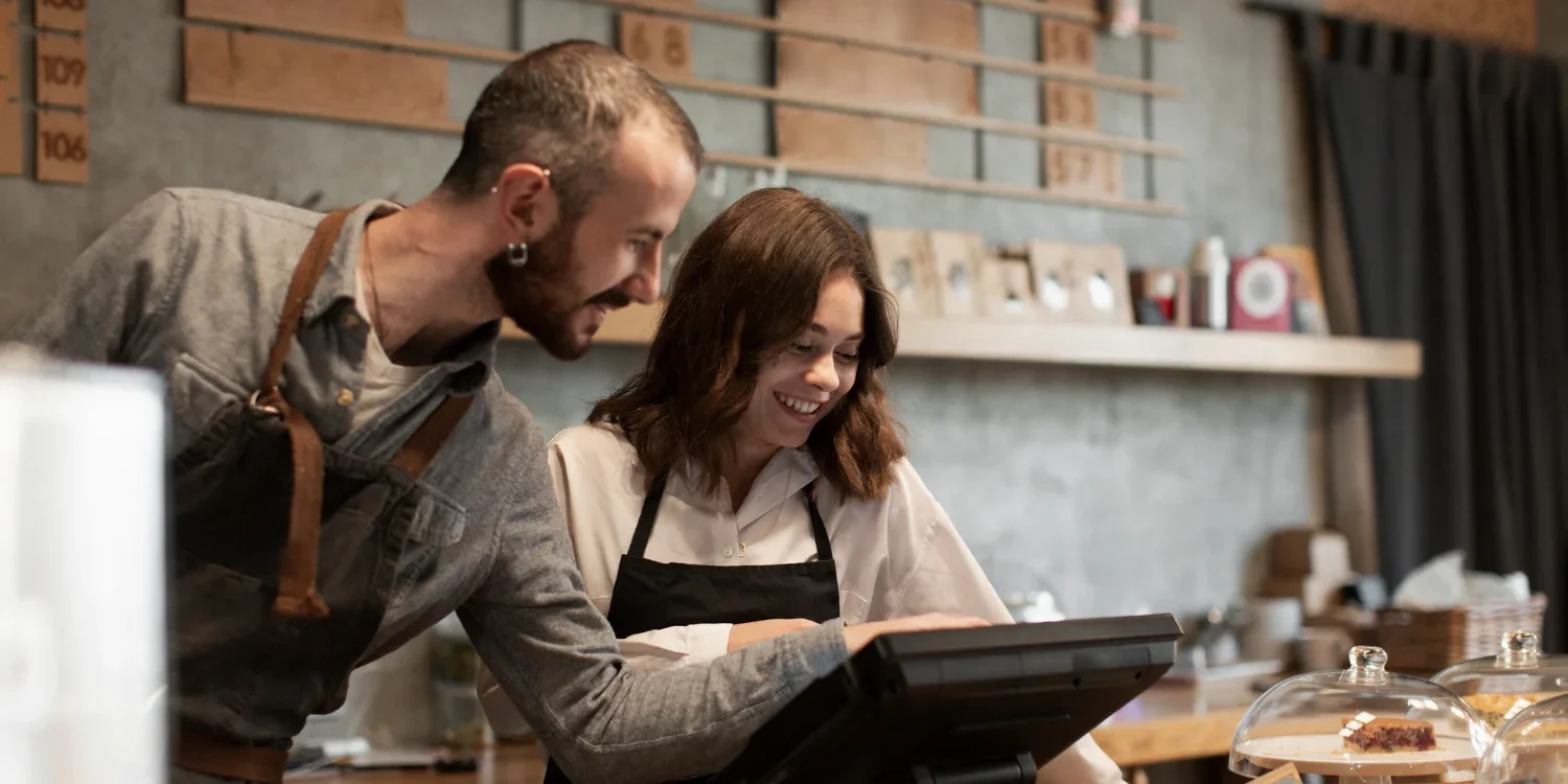Restaurant staff using a laptop to manage online reservations