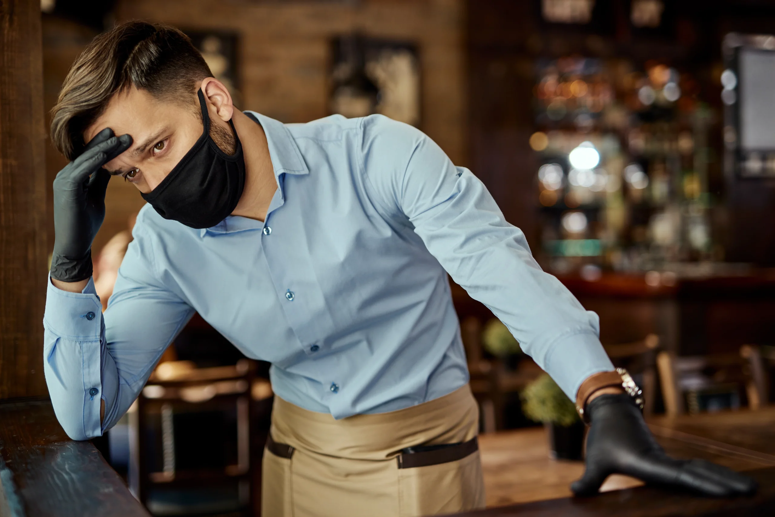 distraughtwaiterholdinghisheadpainwhilewearingprotectivefacemaskworkingpub | Tableo Risiken im Gastgewerbe