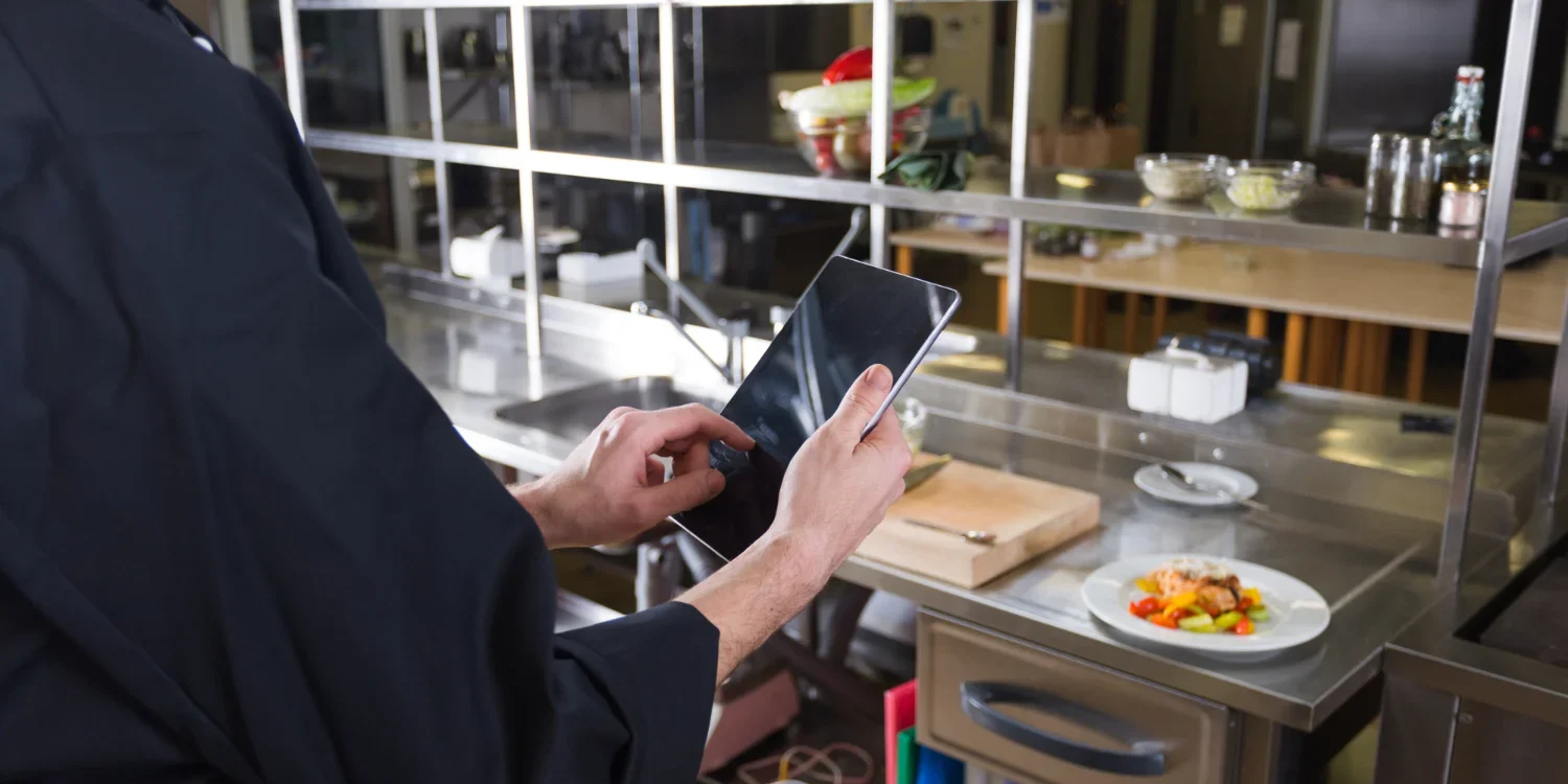 Chef reviewing restaurant inventory checklist in kitchen