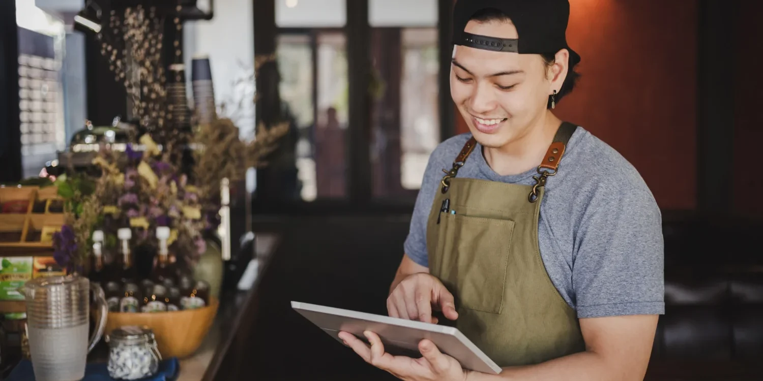 Restaurant owner using digital reservation software on a tablet