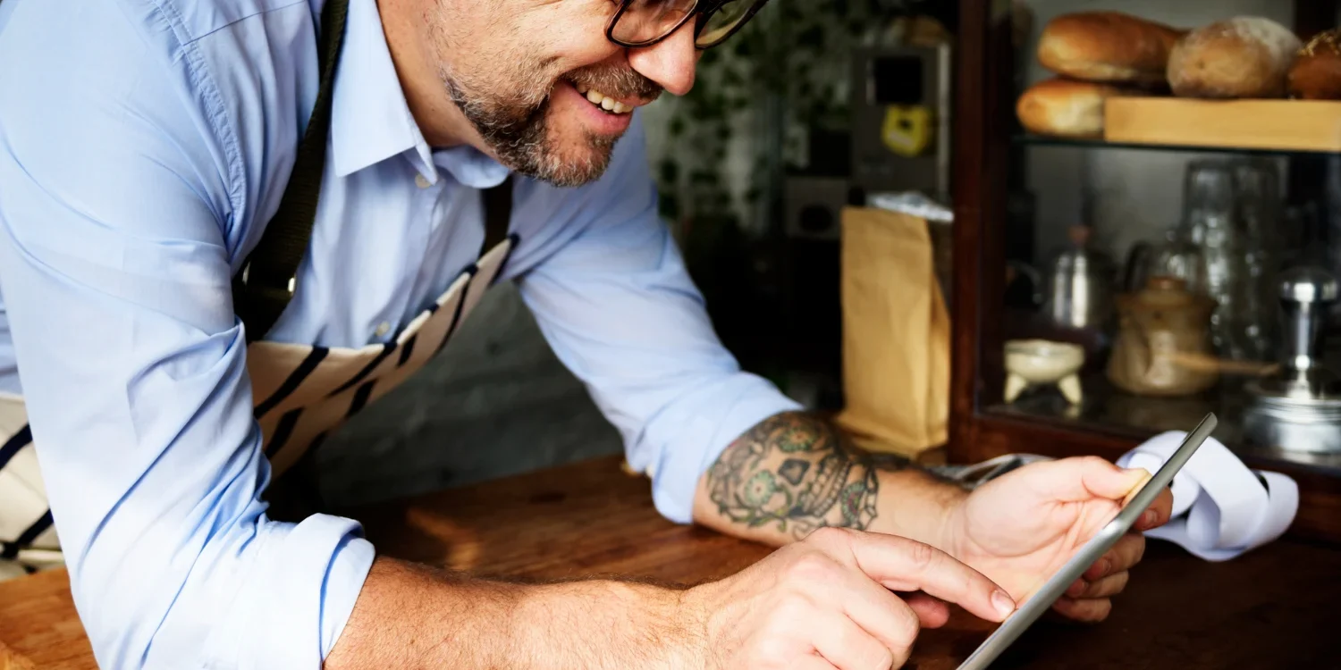 Happy restaurant owner using reservation system